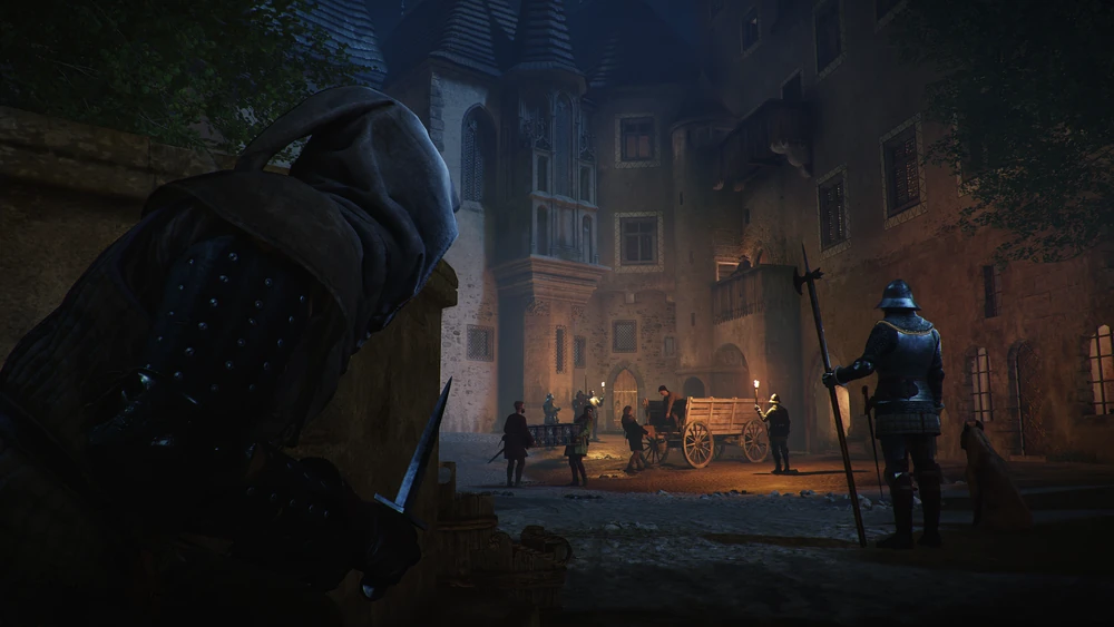 A hooded figure with a dagger watches guards and a cart in a torch-lit town square at night
